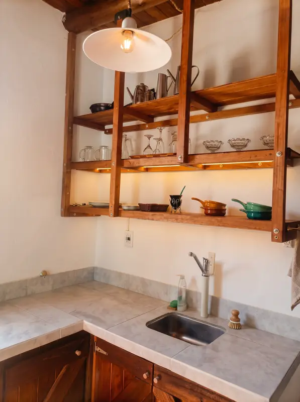 Alacena de madera abierta sobre la bacha de la cocina