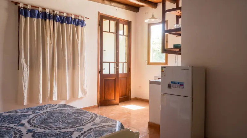 Puerta ventana de madera, cortinas y heladera