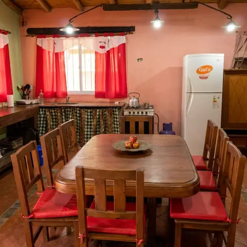 Cocina con heladera y mesa de madera