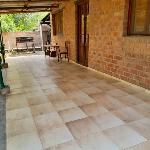 Galería techada con piso cerámico junto a la cabaña